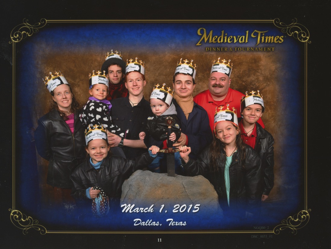 Medieval times Stone Wall Background. Excalibur prop that Bernie, Becket and Jacinta have their hands on. Jen, Bernie, Michael holding Catie, Joseph, Nunzio Holding Becket, Justin, Jacinta and Cross. Bottom Text: 'Dallas, Texas March 1, 2015'